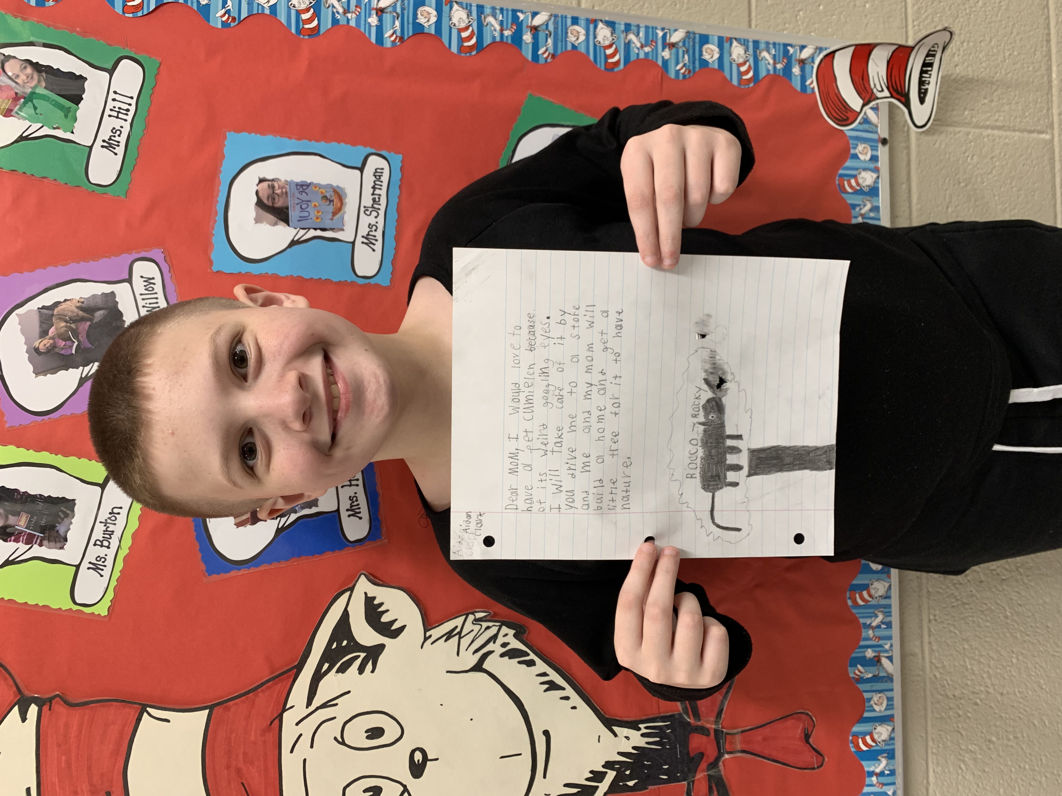 Student is shown holding their writing.